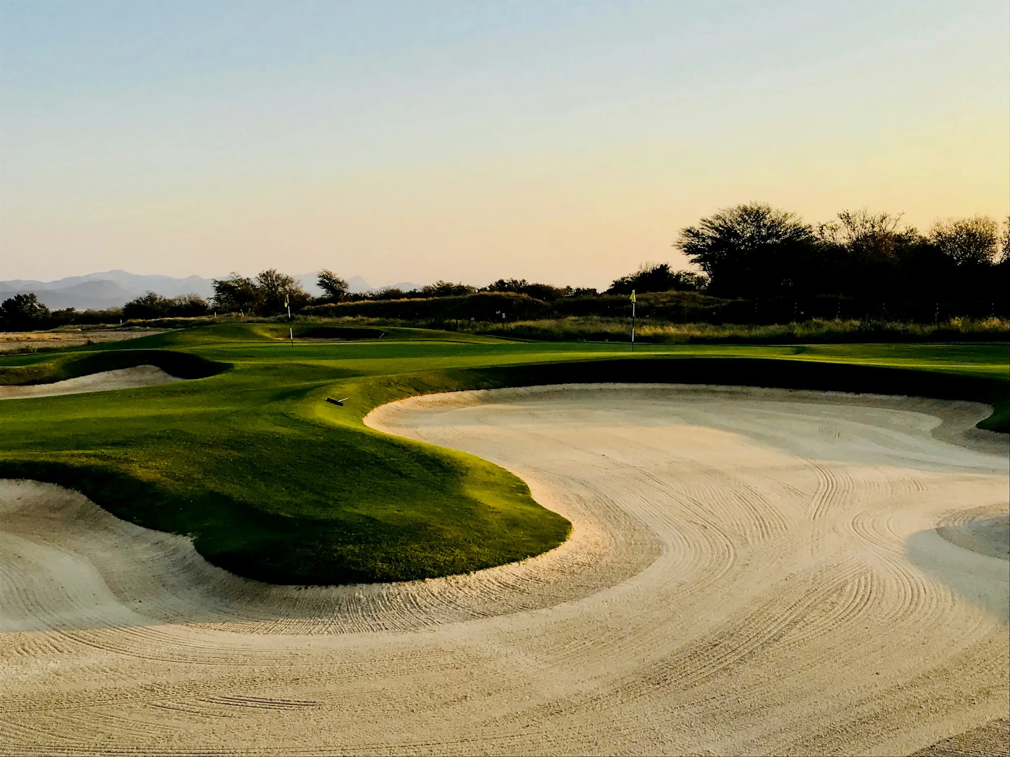 Golfplatz mit Sandbunker und welligem Fairway