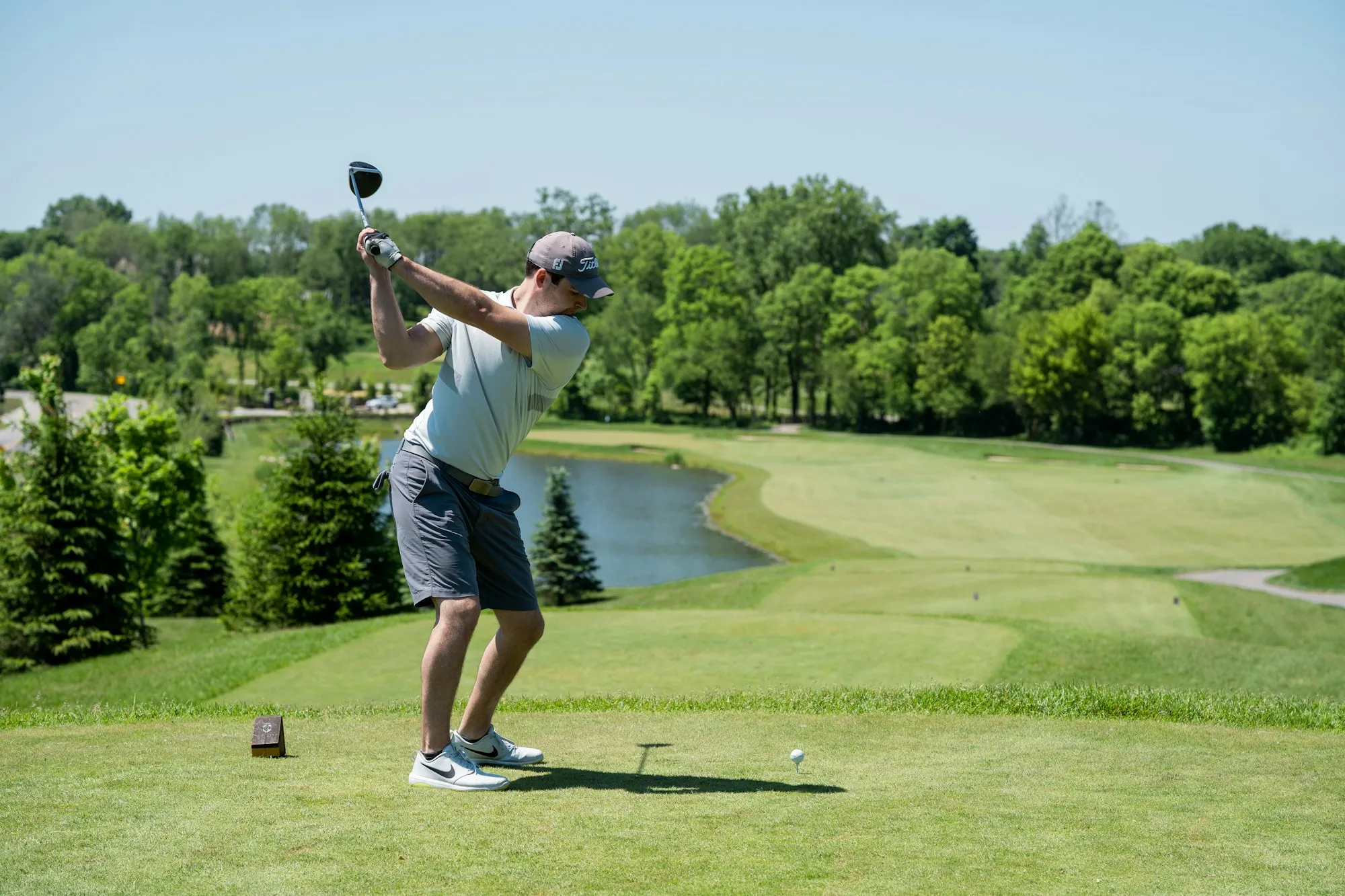 Golfer beim Abschlag auf einem grünen Fairway