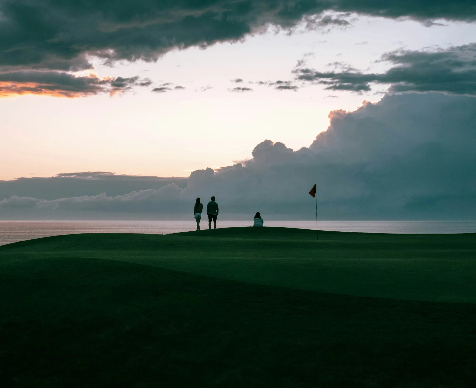 Zwei Golfer gehen in der Abenddämmerung über den Golfplatz
